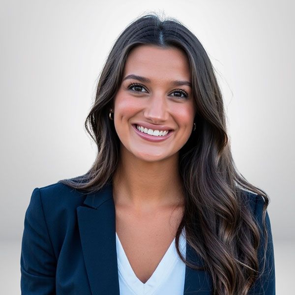 Smiling woman in a business suit with long hair against a neutral background.