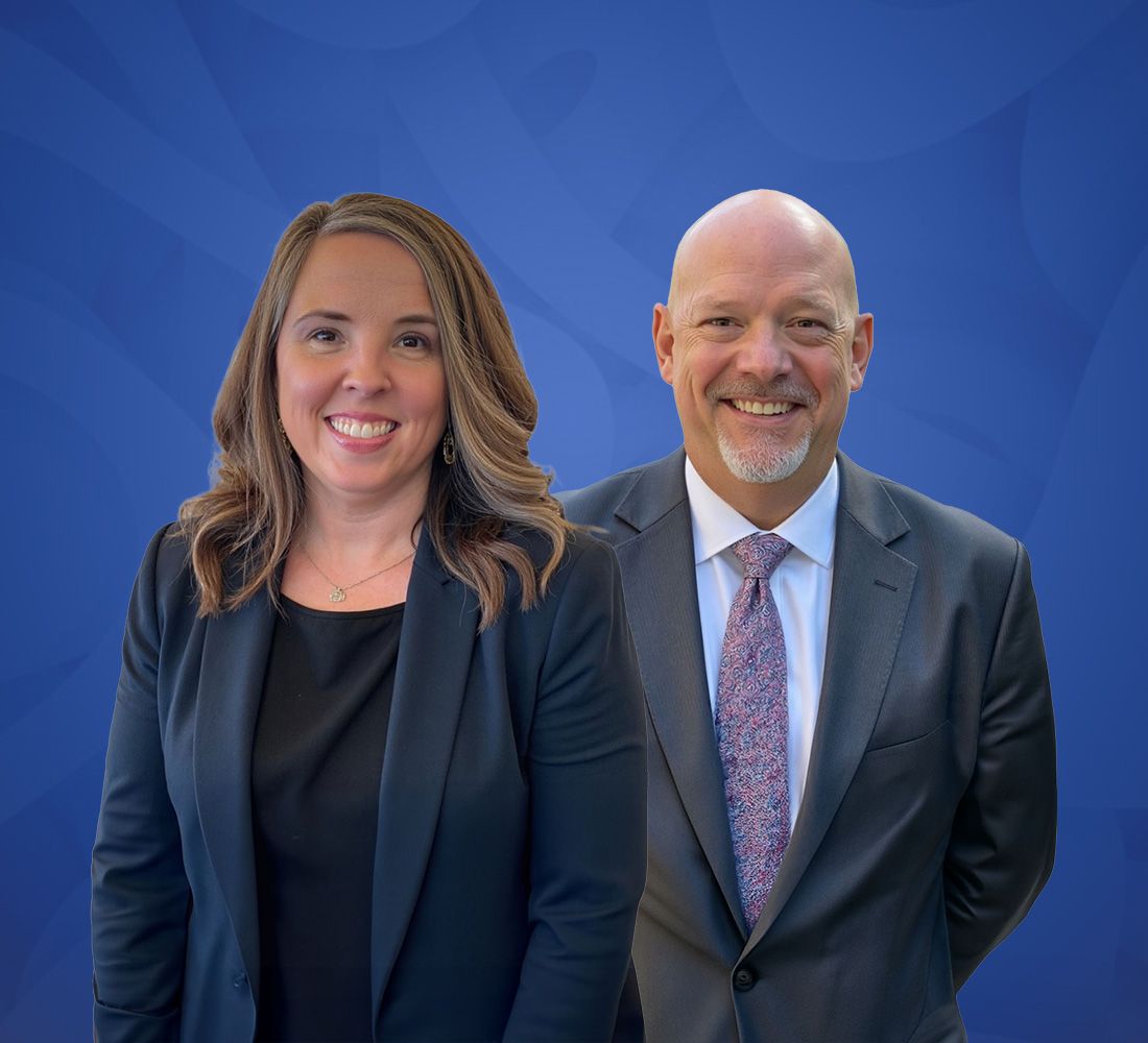 Two people in business attire, smiling against a blue background.