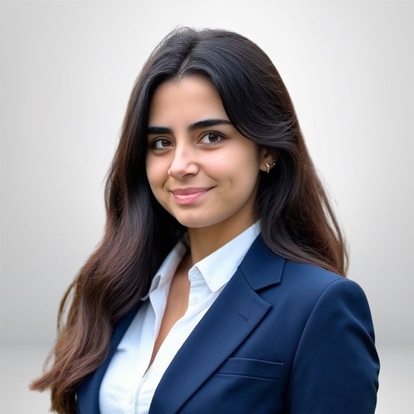 Smiling woman in a blue blazer with long hair, posing against a neutral background.
