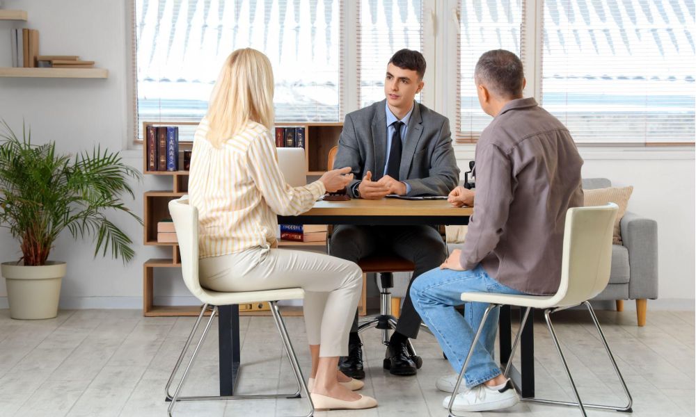 Business meeting with a couple discussing with a professional in a modern office setting.