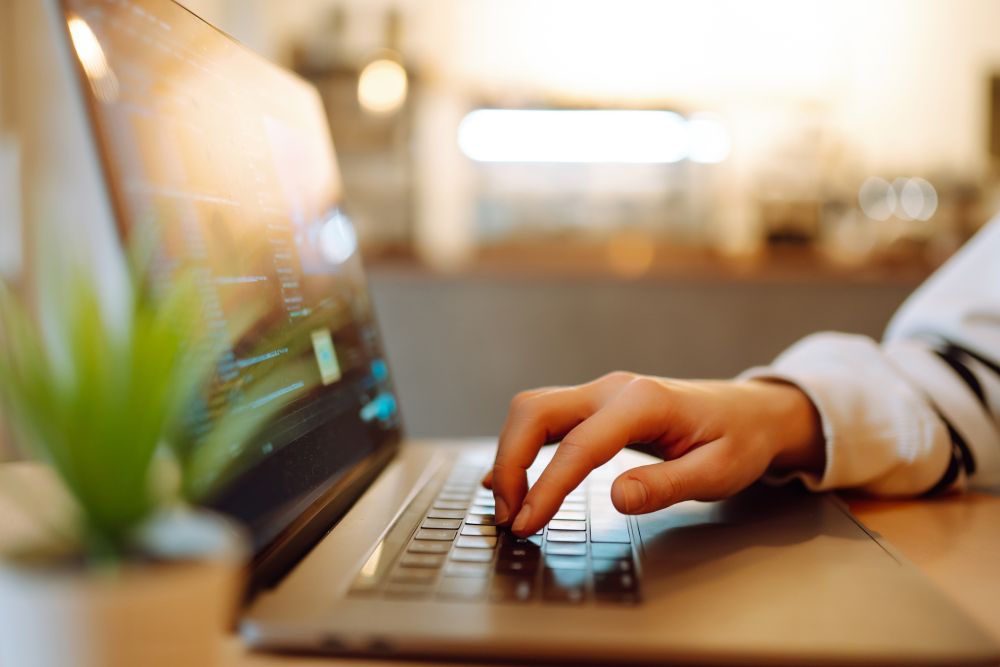 Close- up picture of female hands working on her laptop.
