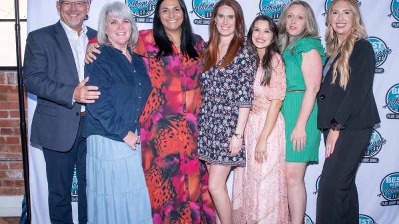 Group of smiling people at a Best of the Albemarle event backdrop.