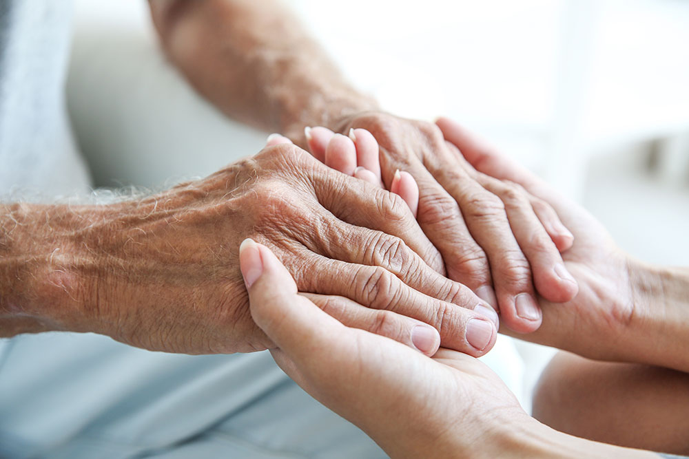 Elderly hands held with care, symbolizing support and compassion in a nurturing environment.
