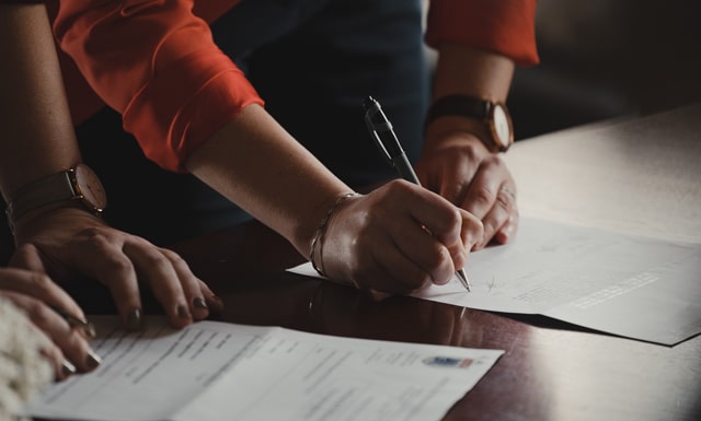 Feature / Benefit Textarea – Parks Zeigler, PLLC Person Signing Documents on a Table Focusing on Hands and Paperwork Emphasizing Important Tasks or Agreements